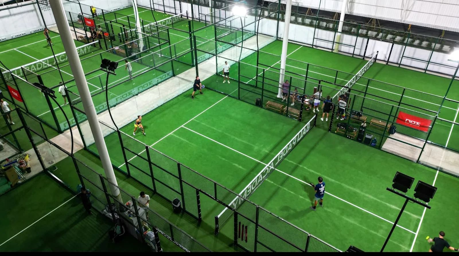 Green padel courts and players inside Bali Padel Academy
